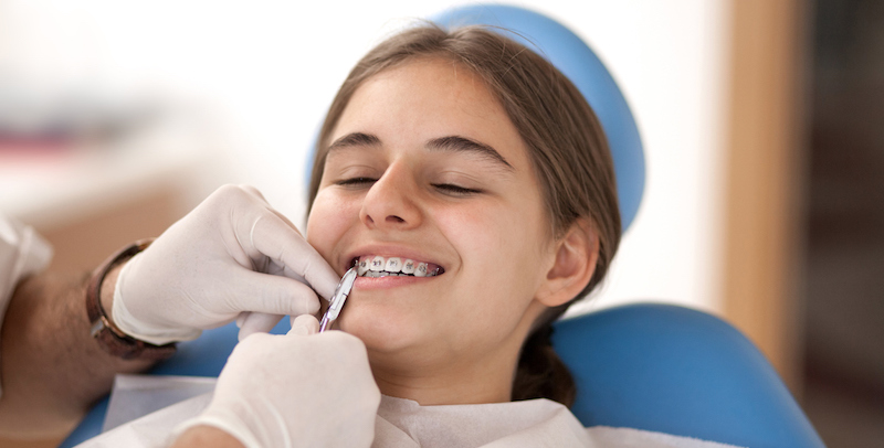 young girl in a dental chair having her braces taken off