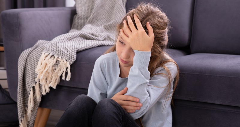 A young girl with a headache caused by an overbite