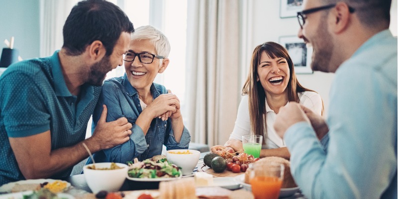 People laughing and enjoying a family meal after taking their Invisalign out to eat.