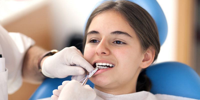 young girl having her braces put on