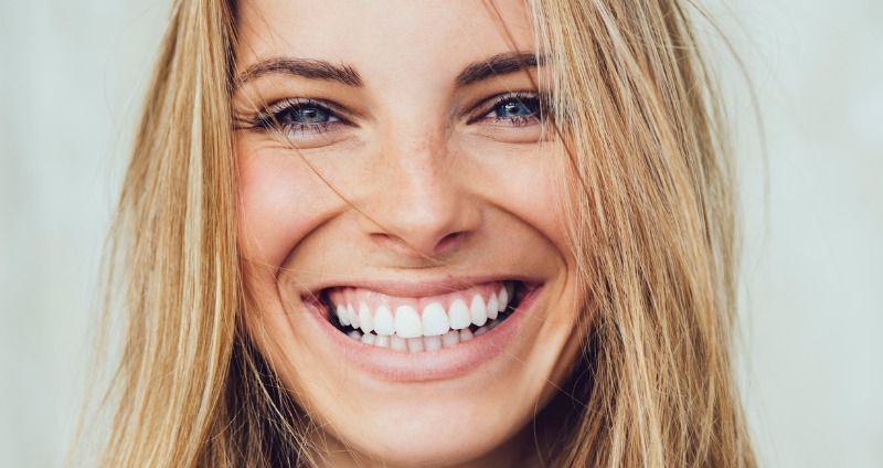 Female smiling with teeth showing the relationship between a face and a smile