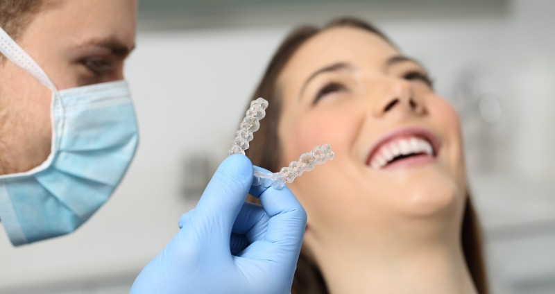 An orthodontist fitting a patient with an invisalign clean aligner