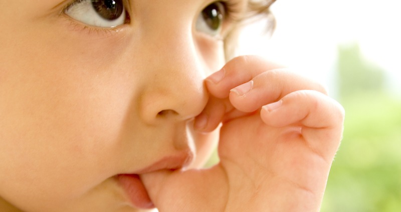 A young toddler sucking her thumb
