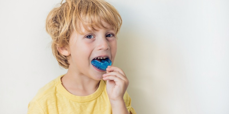 Young boy putting in a mouthguard