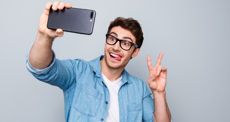 A guy smiling for a selfie with white teeth. Invisalign doesn’t show up in photos.