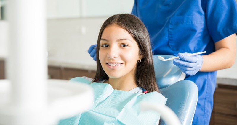 young girl having her braces put on