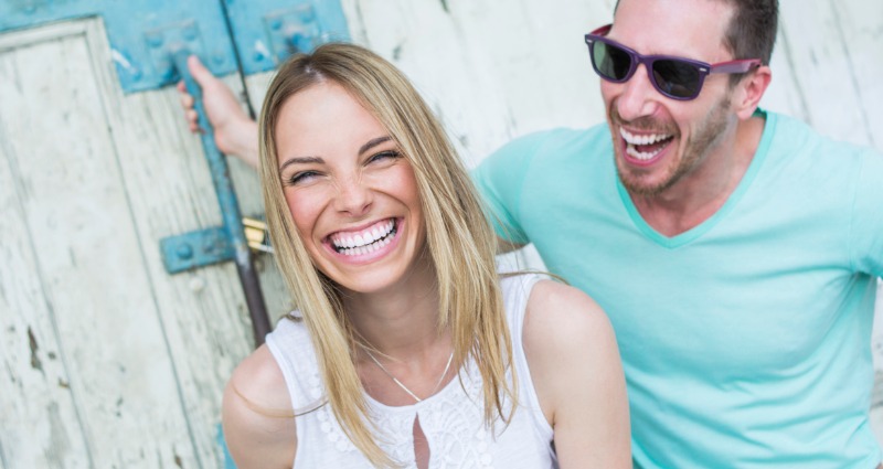 A smiling young woman while asking how long does invisalign take to straighten my teeth.