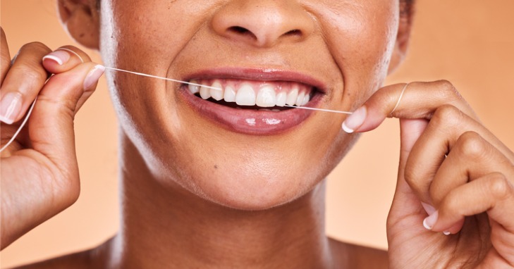 Women flossing teeth below the wire to prevent gum disease and cavities