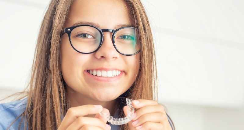 Young girl with invisalign smiling staying on track with her treatment during COVID-19 