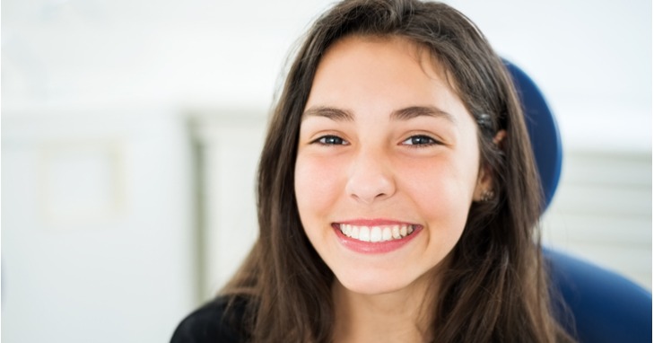 A girl smiling with straight, white teeth 
