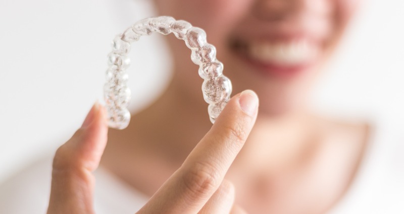 Young female holding her orthodontic retainer 