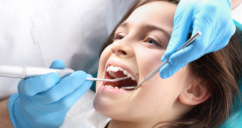 young female child having her teeth checked by an orthodontist 